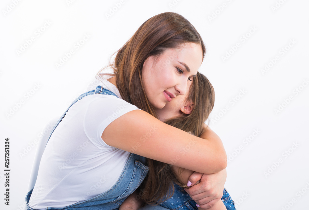 Motherhood, family and relationship concept - Happy mother and little daughter having fun on white background