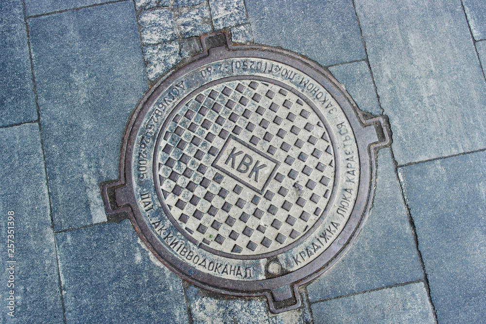 manhole on the background of gray paving slabs