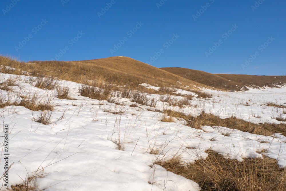Spring landscape. The hills. Sunny day and melting snow.