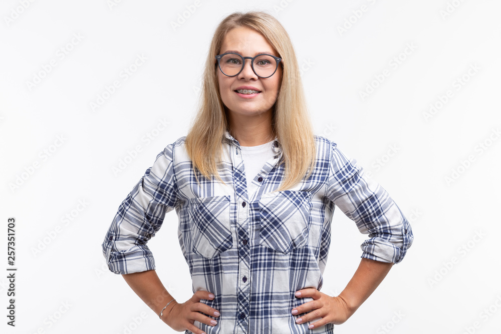 Teeth health, dentistry and bite correction - Happy smiling woman in glasses with braces on white background Teeth health, dentistry and bite correction - Happy smiling woman in glasses with braces on white background