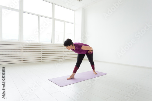 Sport  yoga  people concept - Sporty middle-aged woman practicing yoga indoors