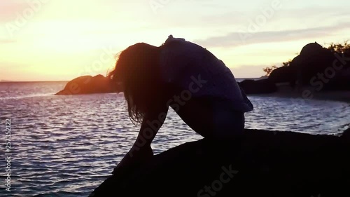 Pensive sad young woman on beach looking at the sea during amazing sunset. Slow Motion. 1920x1080