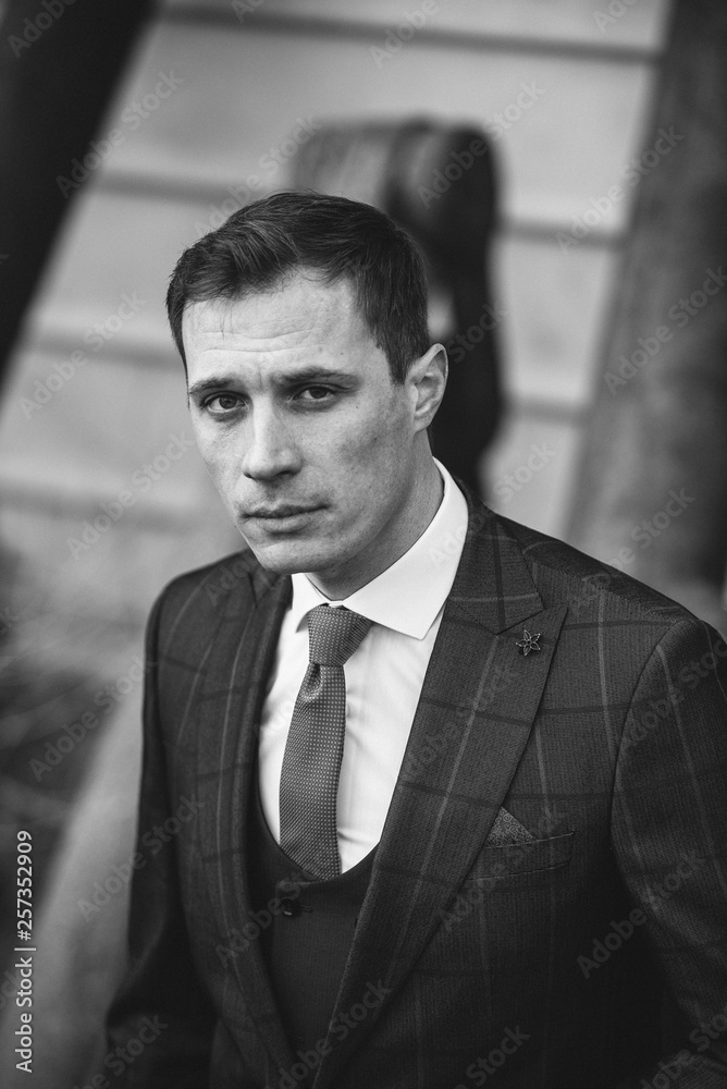 A man in a checkered suit poses on the street to advertise men's clothing. Black and white photo. Advertising menswear A man in a checkered suit poses on the street to advertise men's clothing. Black and white photo. Advertising menswear