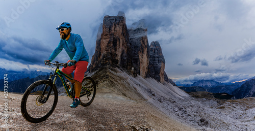 Cycling man riding on bikes in Dolomites mountains landscape. Cycling MTB enduro trail track. Outdoor sport activity.