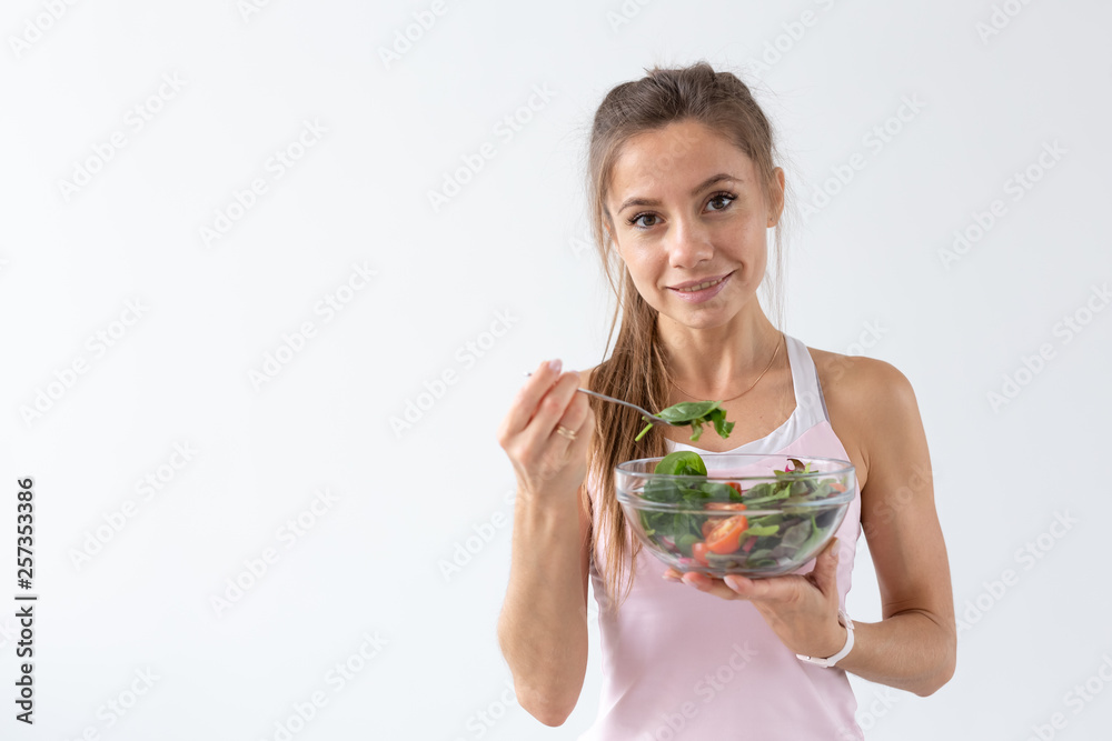People, food and diet concept - Portrait of woman eating healthy food over white background with copy space People, food and diet concept - Portrait of woman eating healthy food over white background with copy space