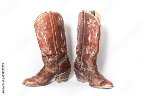 Old dirty cowboy boots on a white background photo
