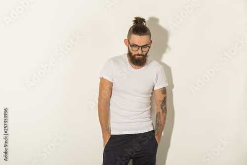 Beauty, fashion and people concept - Hipster man with beard posing over white background