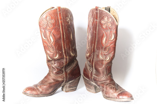 Old dirty cowboy boots on a white background