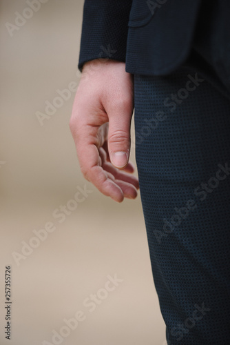 A man with a beard in a blue suit poses on the street to advertise men's clothing. Advertising menswear