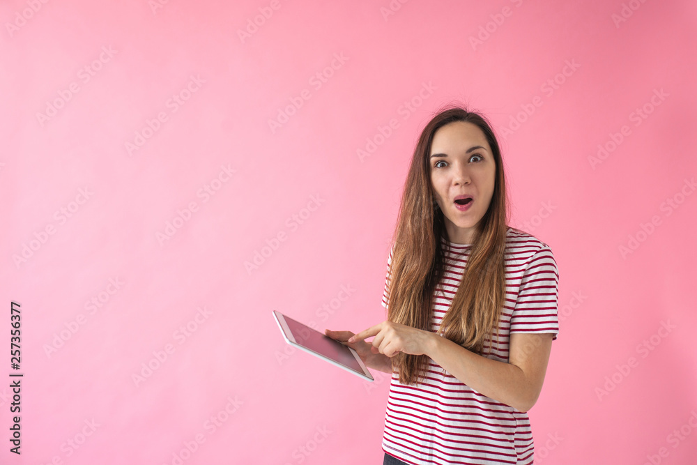 Pleasantly surprised girl uses the tablet. Sale or good news or a good job search or other. Pleasantly surprised girl uses the tablet. Sale or good news or a good job search or other.