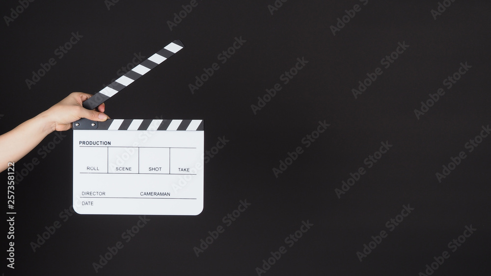 Hand's holding white Clapperboard or Clap board or movie slate use in video production ,film, cinema industry on black background.