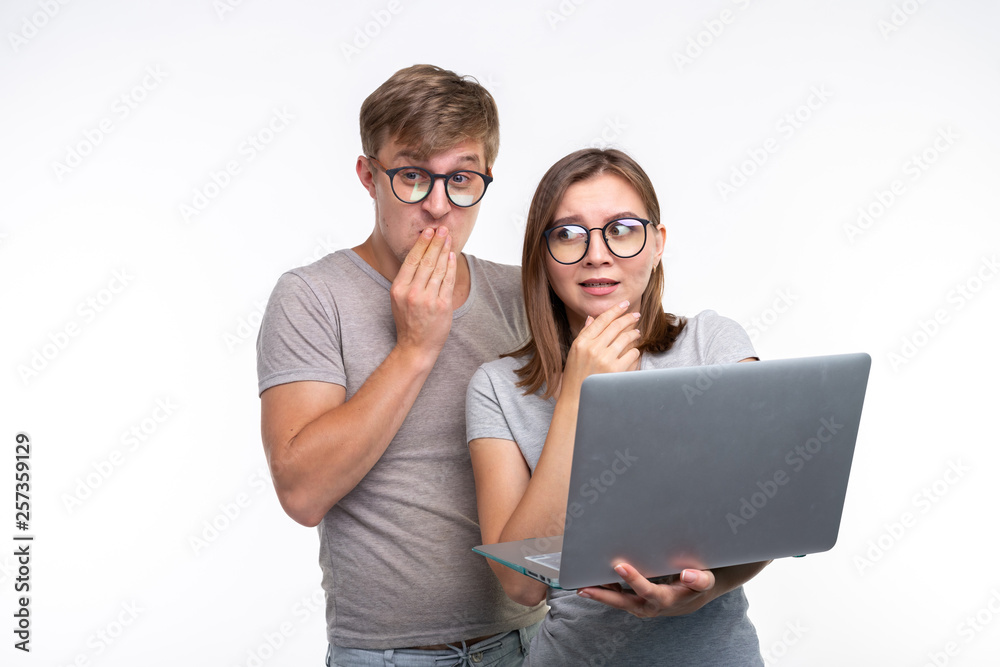 Nerds, study, people concept - a couple of people look at the laptop and look like surprised