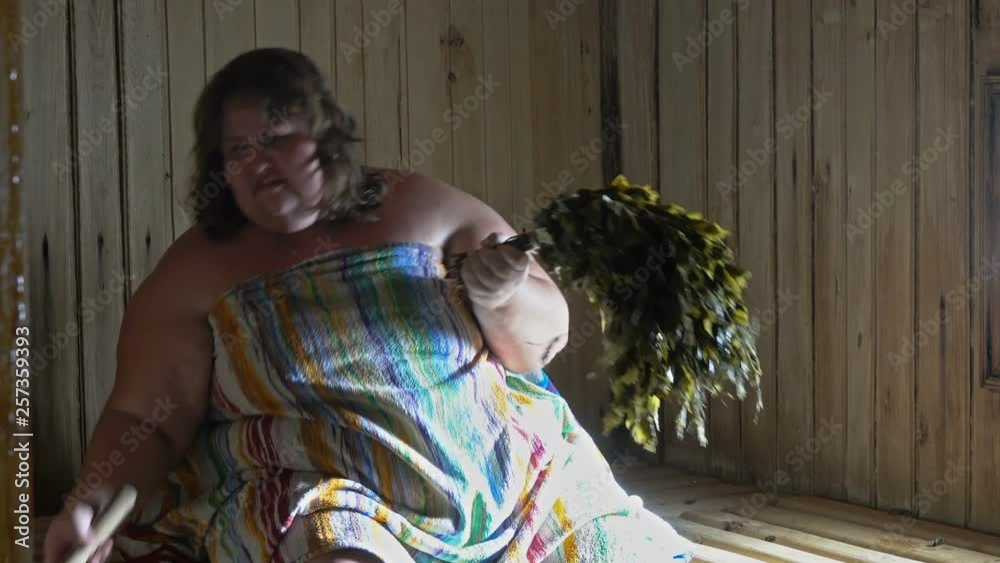 Russian overweight woman in a bathhouse with a broom steamed Stock ビデオ ...