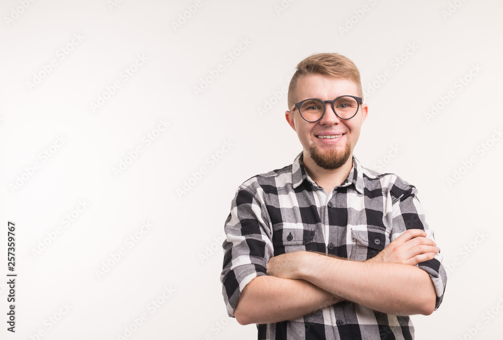 People, nerd and education concept - Smiling handsome student man in plaid shirt, crossed arms, over white background with copy space People, nerd and education concept - Smiling handsome student man in plaid shirt, crossed arms, over white background with copy space