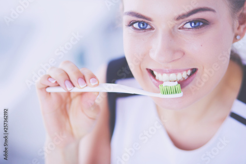 Young pretty girl maintaining oral hygiene with toothbrush.