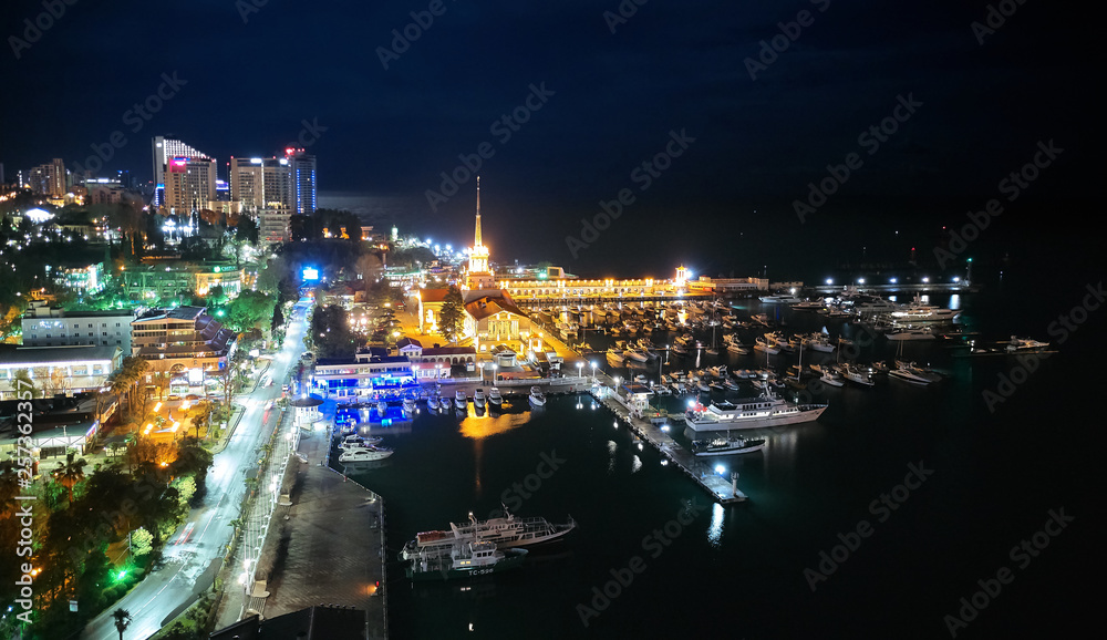 Sochi sea port. Aerial drone. Berth for marine yachts and boats. The historic building of the seaport. Evening illumination of the city. Sochi sea port. Aerial drone. Berth for marine yachts and boats. The historic building of the seaport. Evening illumination of the city.
