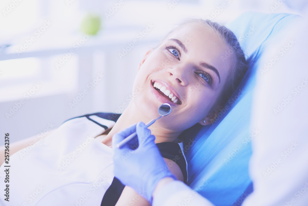 Young Female patient with pretty smile examining dental inspection at dentist office. Young Female patient with pretty smile examining dental inspection at dentist office.