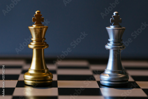 Close up shot of golden and silver chess kings placed against each other on chessboard