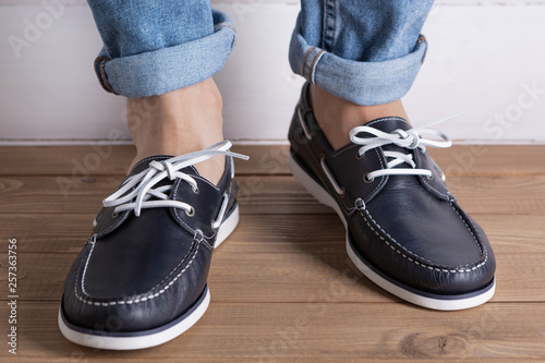 men s legs in blue shoes  comfortable summer moccasins  concept