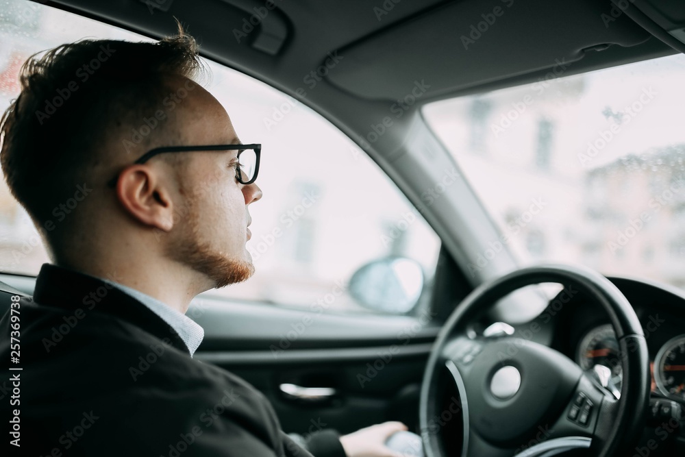 male driver businessman with glasses inside a car