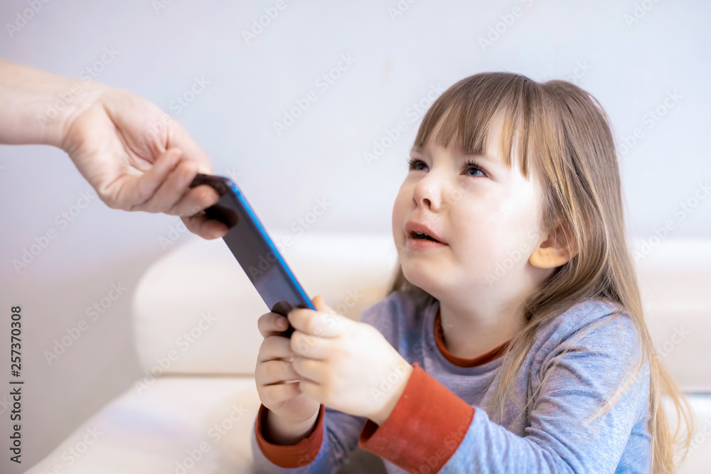 Mother taking away smartphone from her daughter Mother taking away smartphone from her daughter