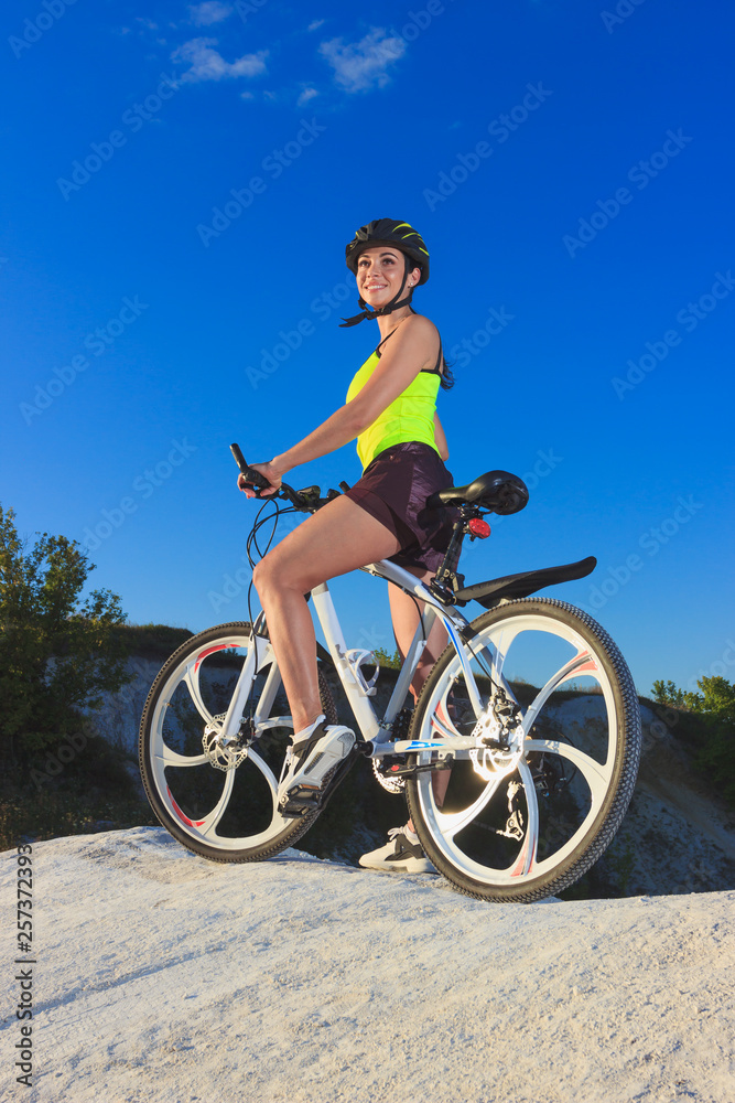 Fototapeta premium Young sporty woman with a bike, soft focus background