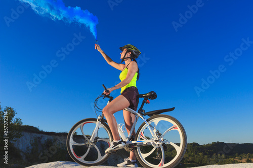 Young sporty woman with a bike, soft focus background