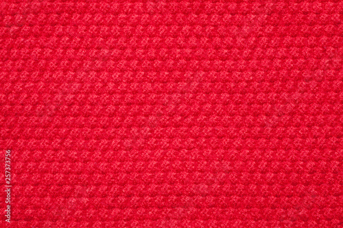 Seamless red knitted fabric background. Close-up.