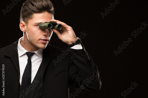Fotografie Close up shot of a handsome professional secret service agent looking away using