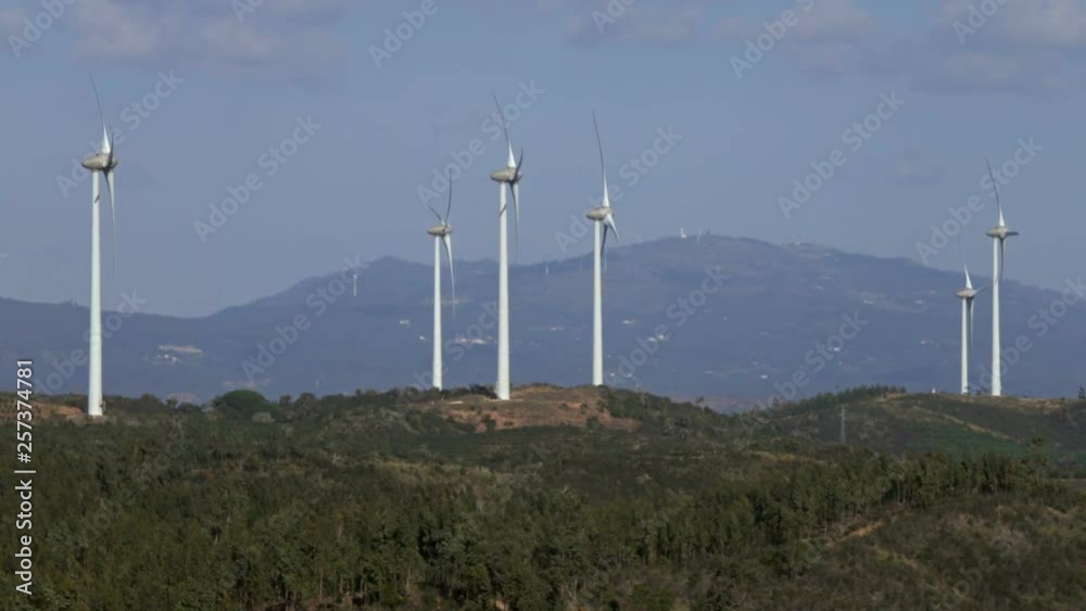 Windmills or wind turbine on wind farm in rotation to generate electricity energy Windmills or wind turbine on wind farm in rotation to generate electricity energy
