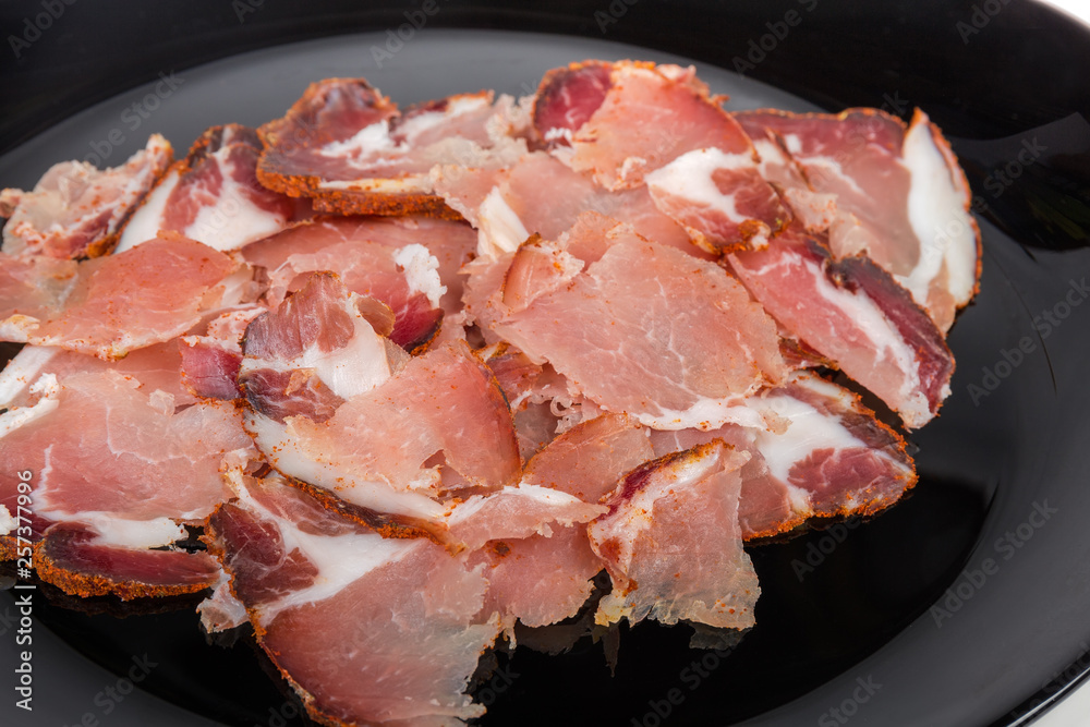 Thin slices of dried pork neck on black dish Thin slices of dried pork neck on black dish