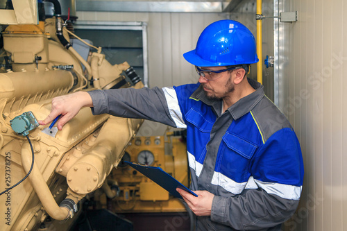 Foto Electromechanic performs repair work on a diesel generator