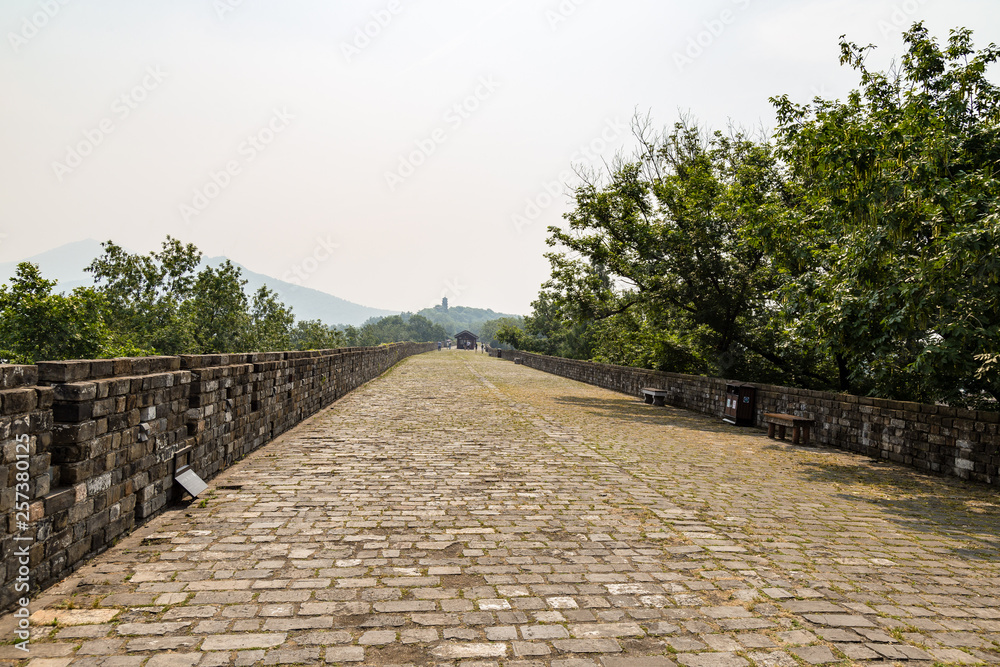 May 2017 - Nanjing, Jiangsu, China - a section of the old Ming Dynasty city walls near Jiming temple. Zijin mountain is visible far away. Nanjing has one of the best preserved city walls of China
