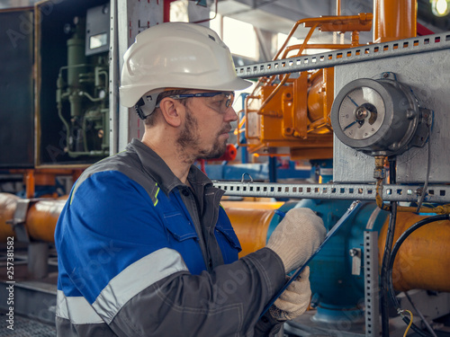 The mechanic - the repairman tightens bolts on a flanged connection of pipeline armature, operator production gas, locksmith repair instrumentation.