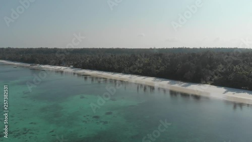 Aerial: flying over coral reef tropical caribbean sea turquoise blue water white beach. Indonesia Kei islands, Moluccas. Top travel destination, diving snorkeling. Native cinelike D-log color profile photo