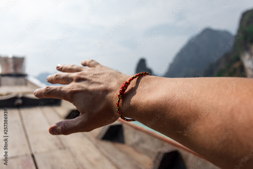 Sacred thai sai sin bracelet provides protection and good health to the  person wearing it. The color of the thread represents different meanings  Stock Photo | Adobe Stock