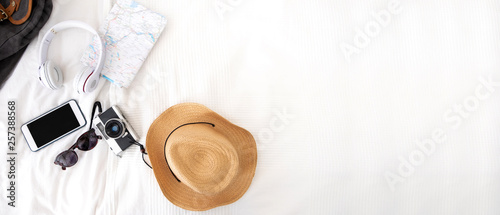 Summer travel items on blanket on bed.Top view of accessories travel (camera,hat,headphone,map ) on bed blankket.prepareing for holiday vacation trip.journey planning.banner for display of design.