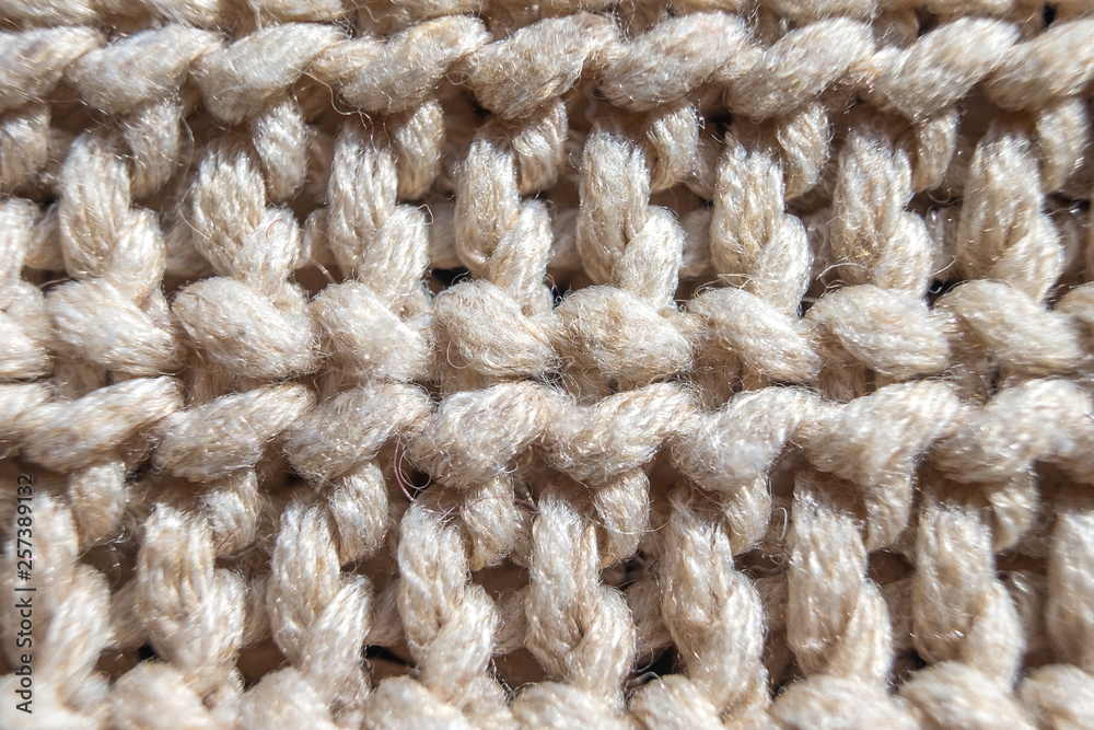 Close-up knit stitching beige close-up, handmade woolen fabric. Close-up knit stitching beige close-up, handmade woolen fabric.