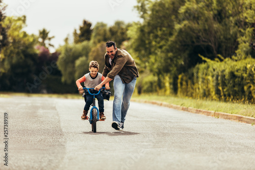 Father teaching his son to ride a bicycle photo