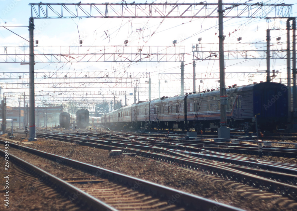 Landscape with the crossing of railway tracks with multiple trains. In the distance everything is lost in the morning fog