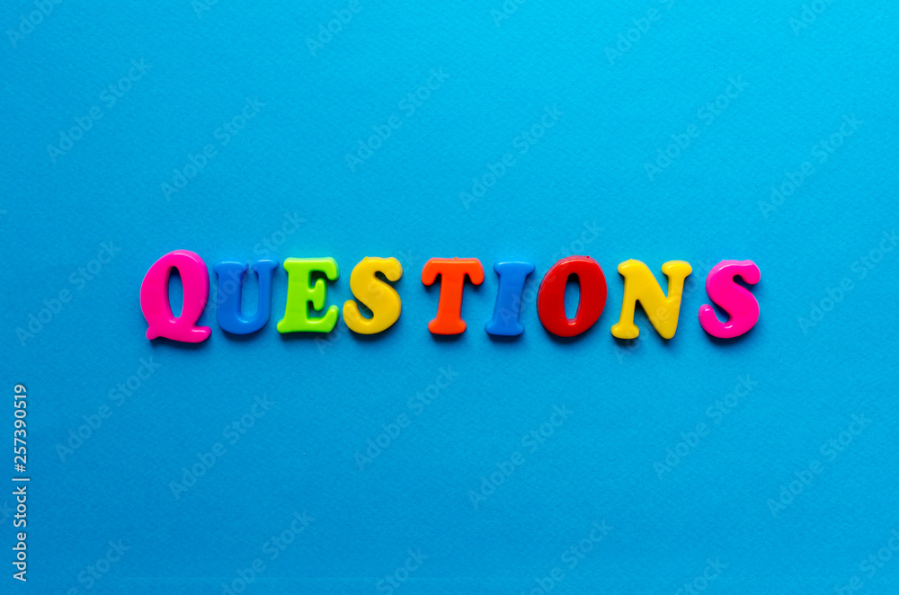 text questions from plastic colored letters on blue paper background text questions from plastic colored letters on blue paper background