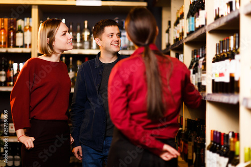 Picture of woman, man and seller from back in store with wine