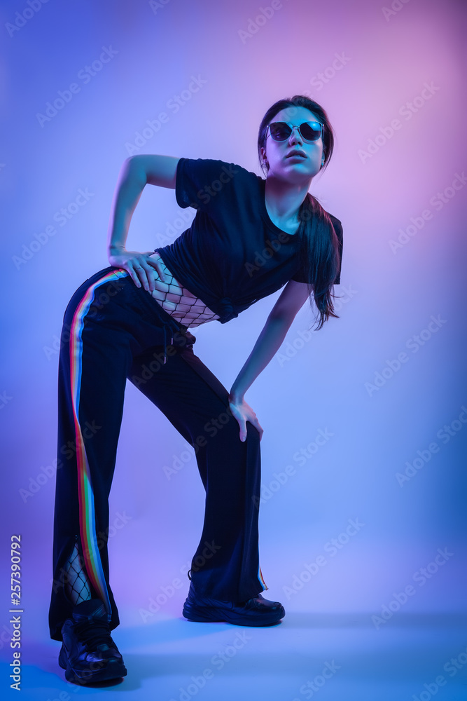 Obraz premium Cinematic night portrait of woman in neon. Art Fashion photo of elegant model in the light colored spotlights.Fashion concept and Zine culture