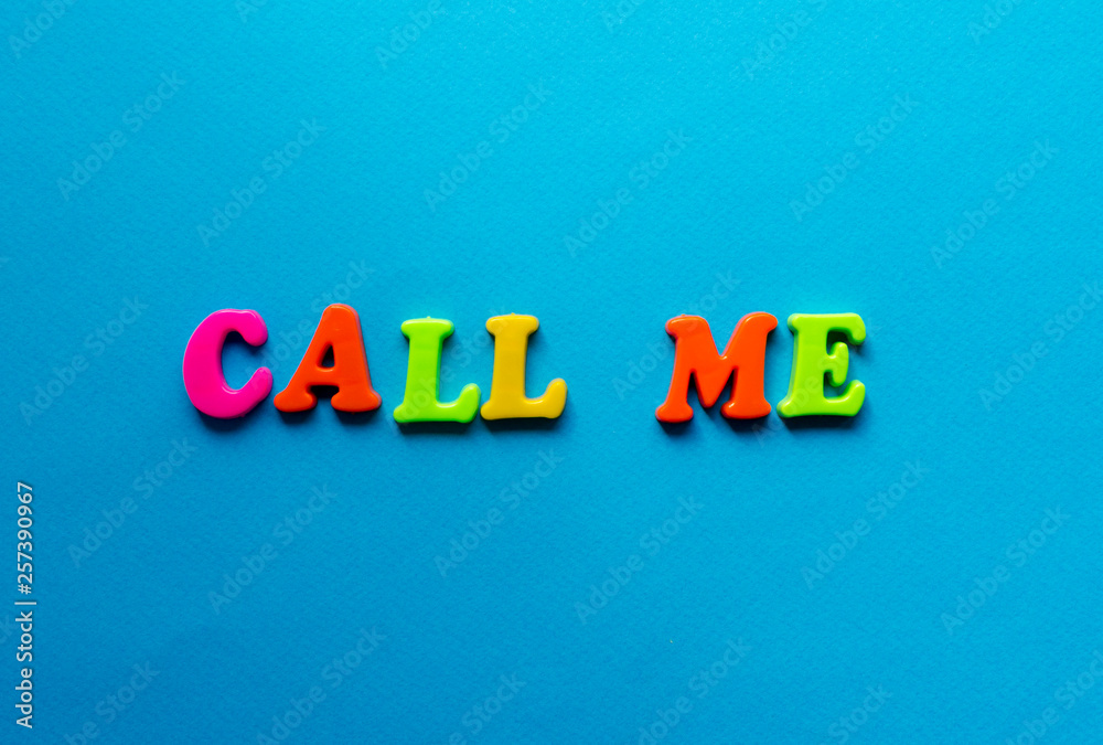 text call me from plastic colored letters on blue paper background text call me from plastic colored letters on blue paper background