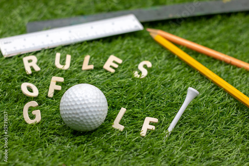 Rules of golf with golf ball on green grass
