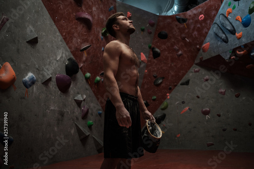 Athletic man using chalk before climbing in a bouldering gym