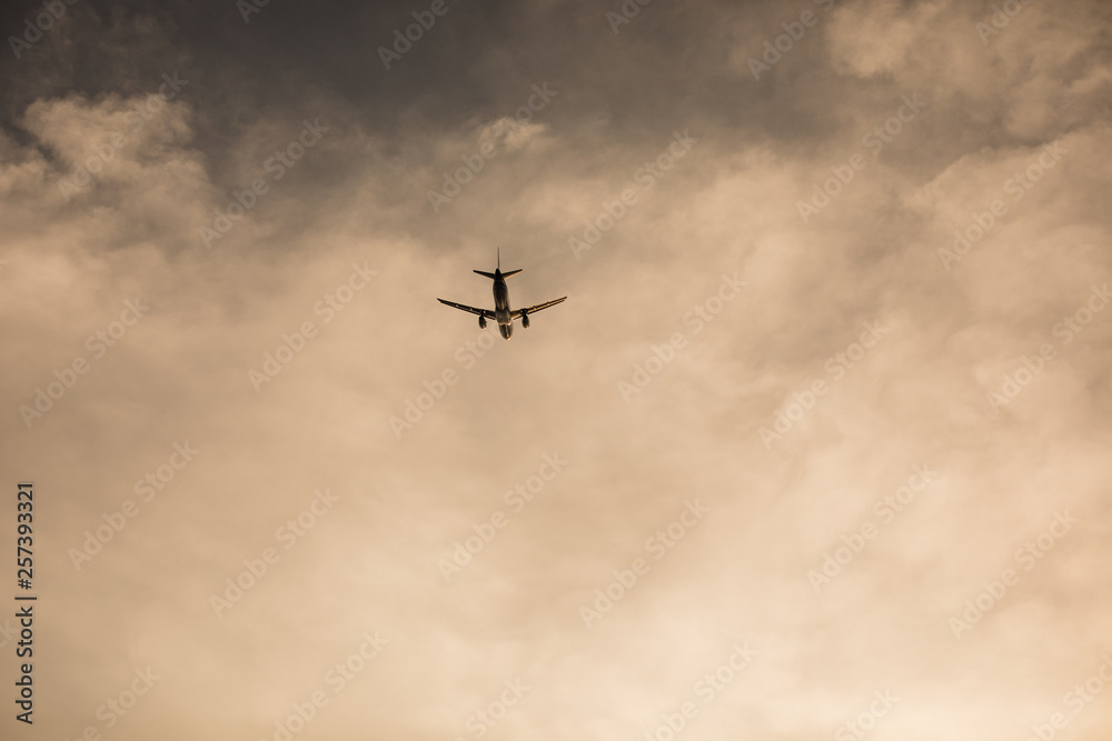 Airplane flying above tropical sea at sunset Airplane flying above tropical sea at sunset