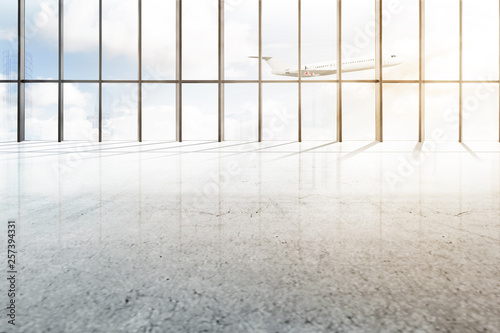 Empty airport hall with window of glass and flying airplane