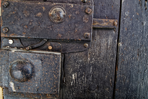 Old wooden door with metal knob and rusty medieval bolt. © Didi