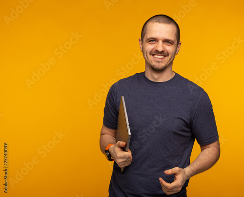 Man developer or freelancer holding laptop and weared in grey t-shirt